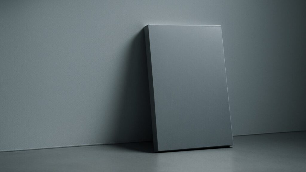 グレーの壁際に立てかけられた四角い影。金属質の反射が加わり、堅実で信頼感ある備えを象徴するミニマルな構図。